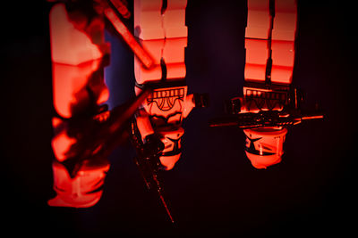 Man standing in illuminated guitar at night