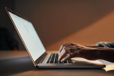 Cropped hand using laptop on table