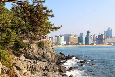 Scenic view of sea by city against clear sky