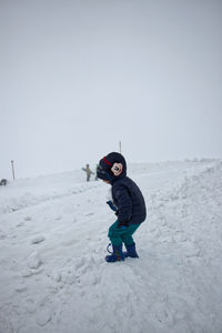 Full length of a boy on snow covered land