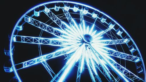 Low angle view of illuminated ferris wheel at night