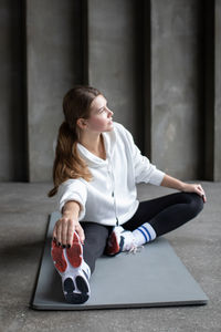 Young woman sitting on floor