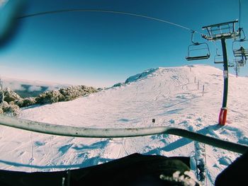 Ski lift over mountains against clear sky