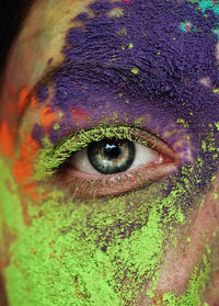 Close-up portrait of woman with multi colored powder paint