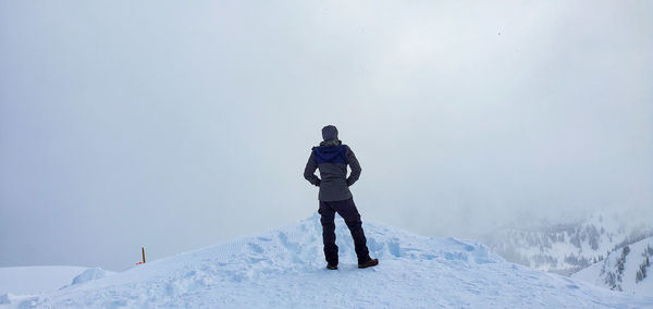 Rear view of person standing on snow covered mountain