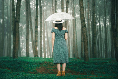 Full length of woman standing in forest