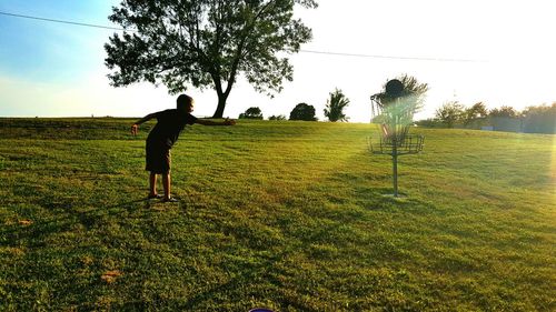 Rear view of woman standing on grassy field