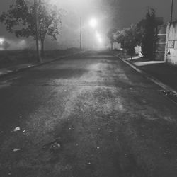 Street amidst trees in city at night