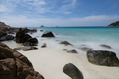 Scenic view of rocks in sea against sky