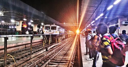 Rear view of people at railroad station at night