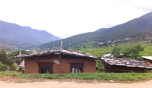 Houses by mountains against sky