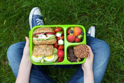 Low section of man with vegetables on field