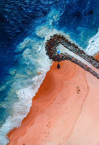 Aerial shot of waves and groin at city beach in perth. western australia