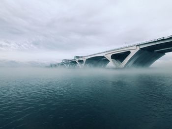 Low angle view of bridge over river against sky