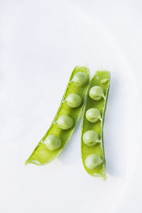 Halved green pea on white background