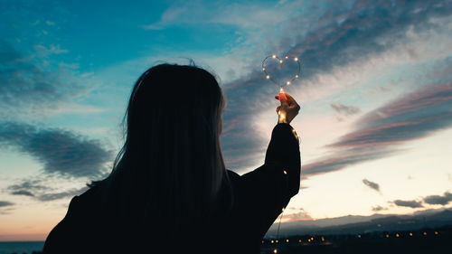 Low angle view of silhouette hand against sky during sunset