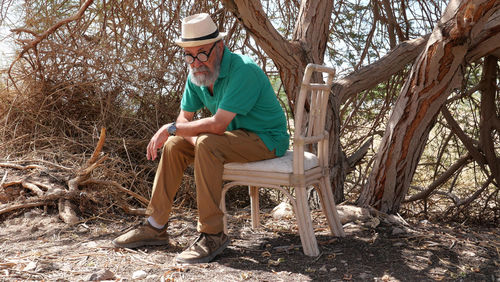 Senior man sitting on seat in the desert 