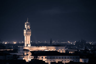 Illuminated buildings in city against sky at night