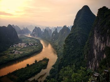 Scenic view of river against sky during sunset