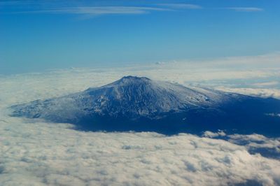 Scenic view of snow covered mountains against blue sky