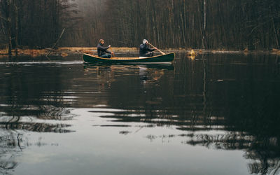 Smiling men boating in lake