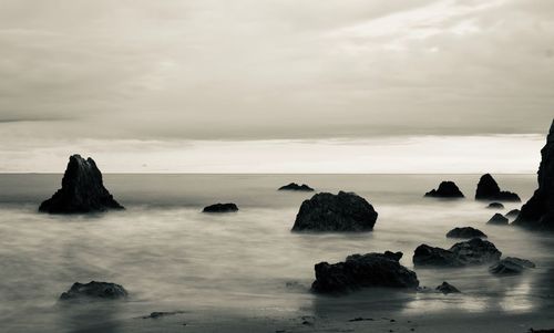 Rocks in sea against sky