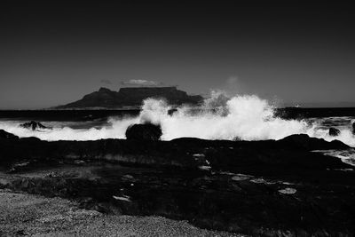 Scenic view of sea waves splashing against sky