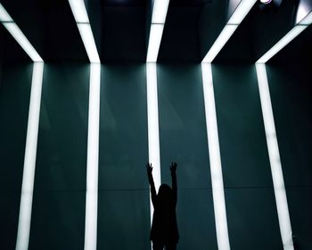 Sunlight streaming through ceiling while woman raising arms