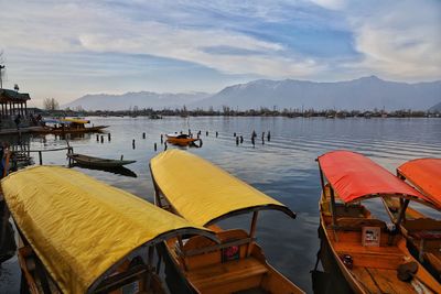 Boats moored in lake against sky