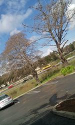 Cars on road against cloudy sky