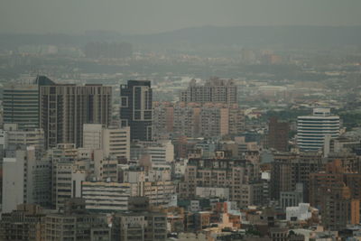 Aerial view of buildings in city against sky