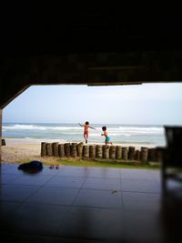 People at beach against sky