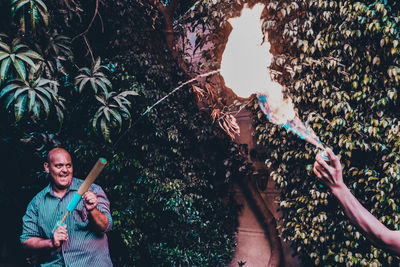 Man pouring water on fire against trees