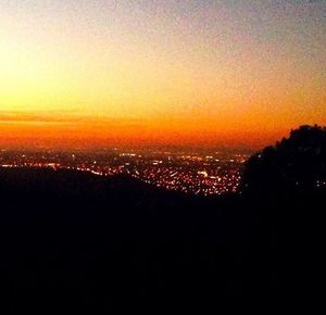 Silhouette cityscape against sky during sunset