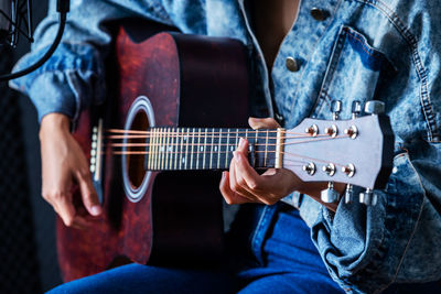 Midsection of man playing guitar