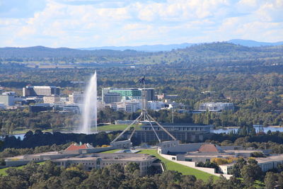 Fountain at parliament house against sky