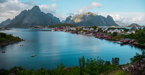 Scenic view of bay and mountains against sky