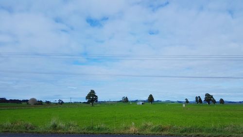 People sitting on field against sky