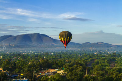 Hot air balloon flying over landscape against sky