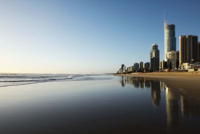 Scenic view of sea by buildings against clear sky