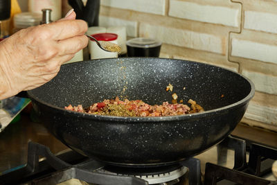 Cropped hand of person preparing food in kitchen