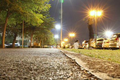 Surface level of street amidst trees at night