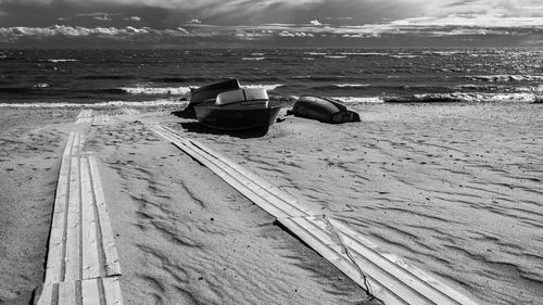 Boat moored on beach against sky