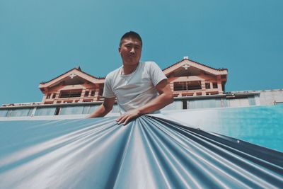 Low angle view of man in swimming pool against sky