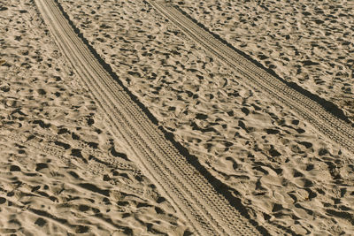 Close-up of tire tracks on sand