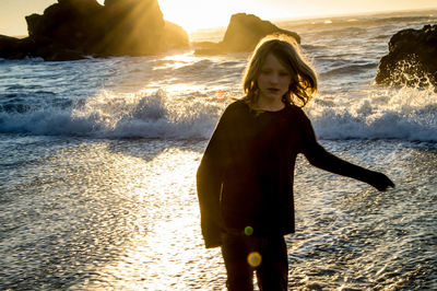 Girl by sea against sky