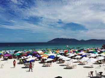 Beach umbrellas on sand against sea