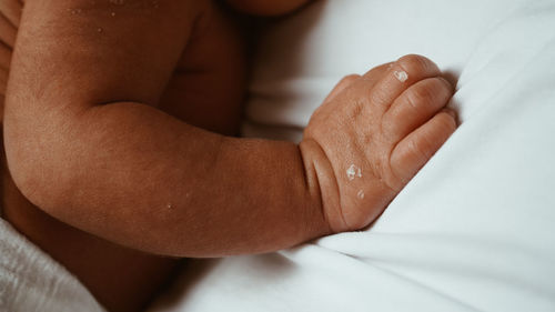 Close-up of man hand on bed