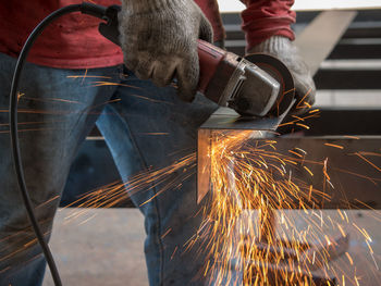 Midsection of man working on metal