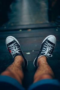 Low section of man wearing shoes on street